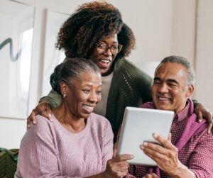 Elderly couple and young woman looking at hand held device