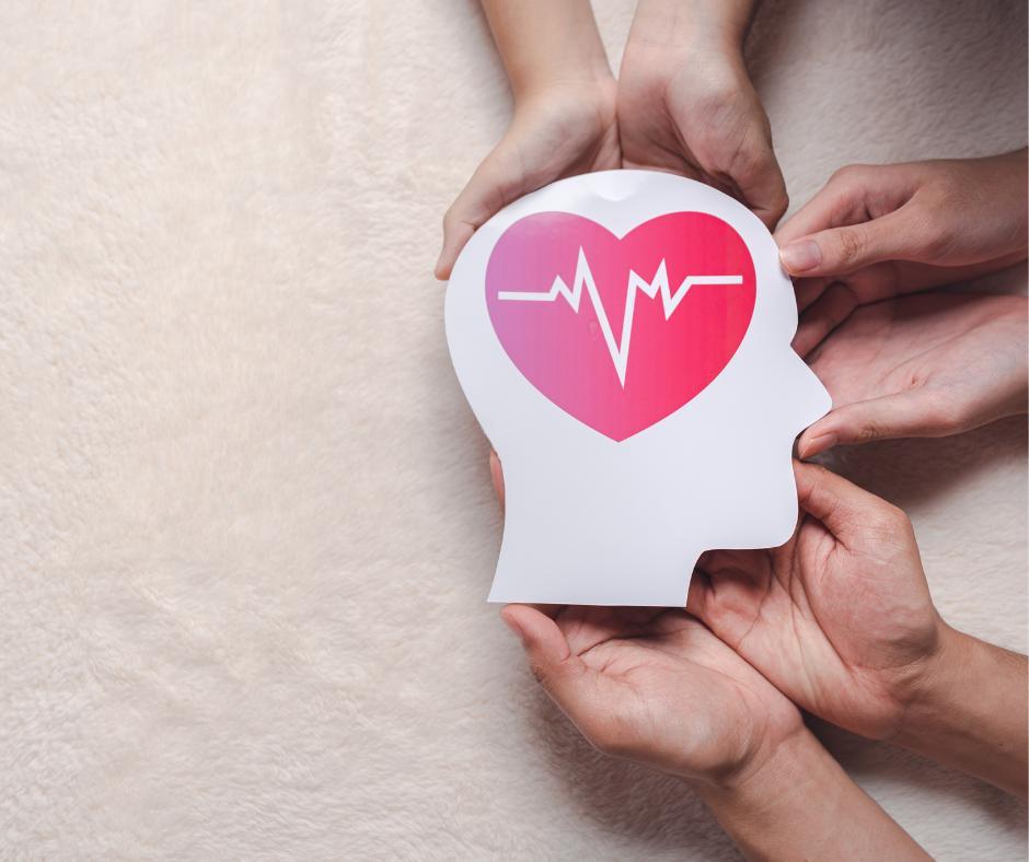 Hands holding paper head cutout. Pink heart in center of head. 