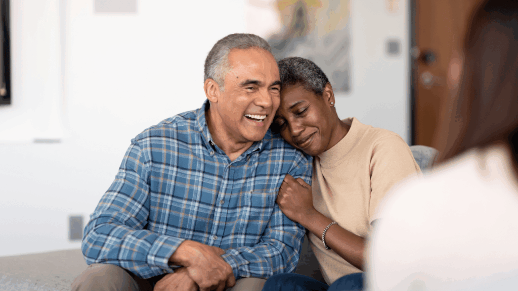 Elderly couple sitting on a couch and embracing