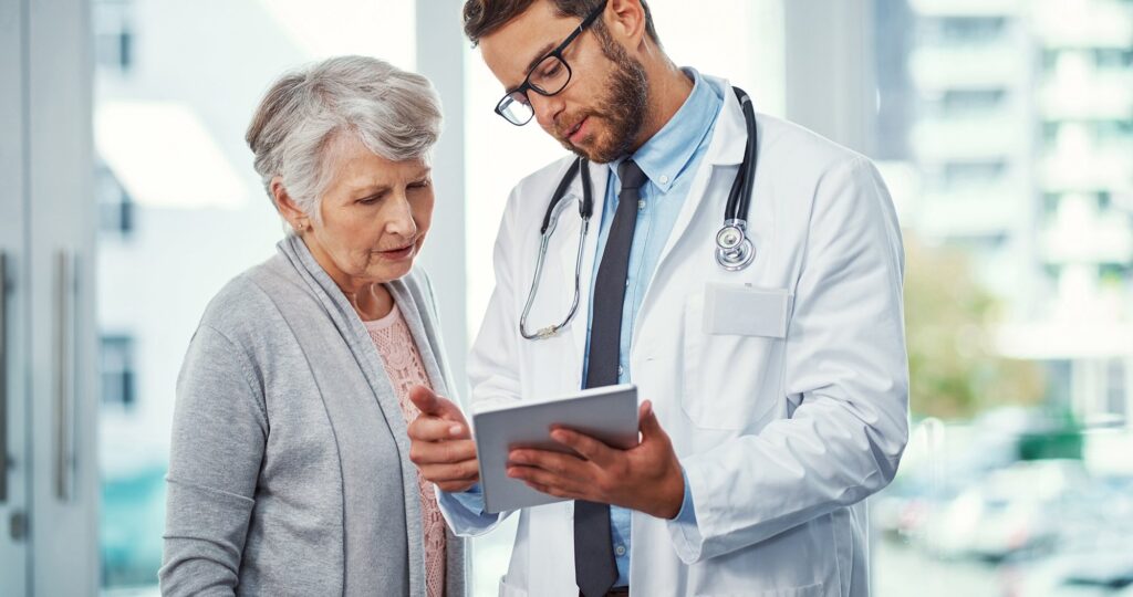a doctor showing his patient information on a tablet