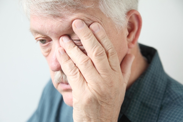 older man holding his head