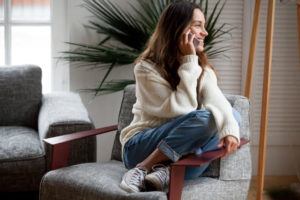 girl sitting in a chair on the phone