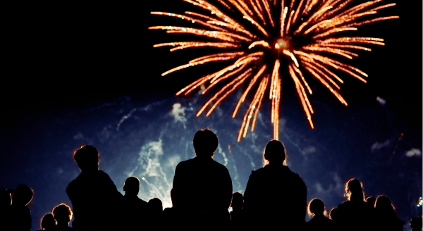 Gathering of people looking up at fireworks