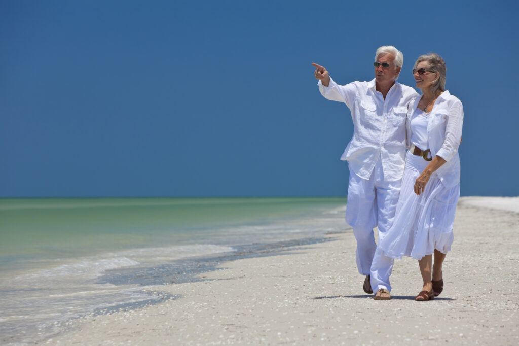 Senior couple walking along beach together