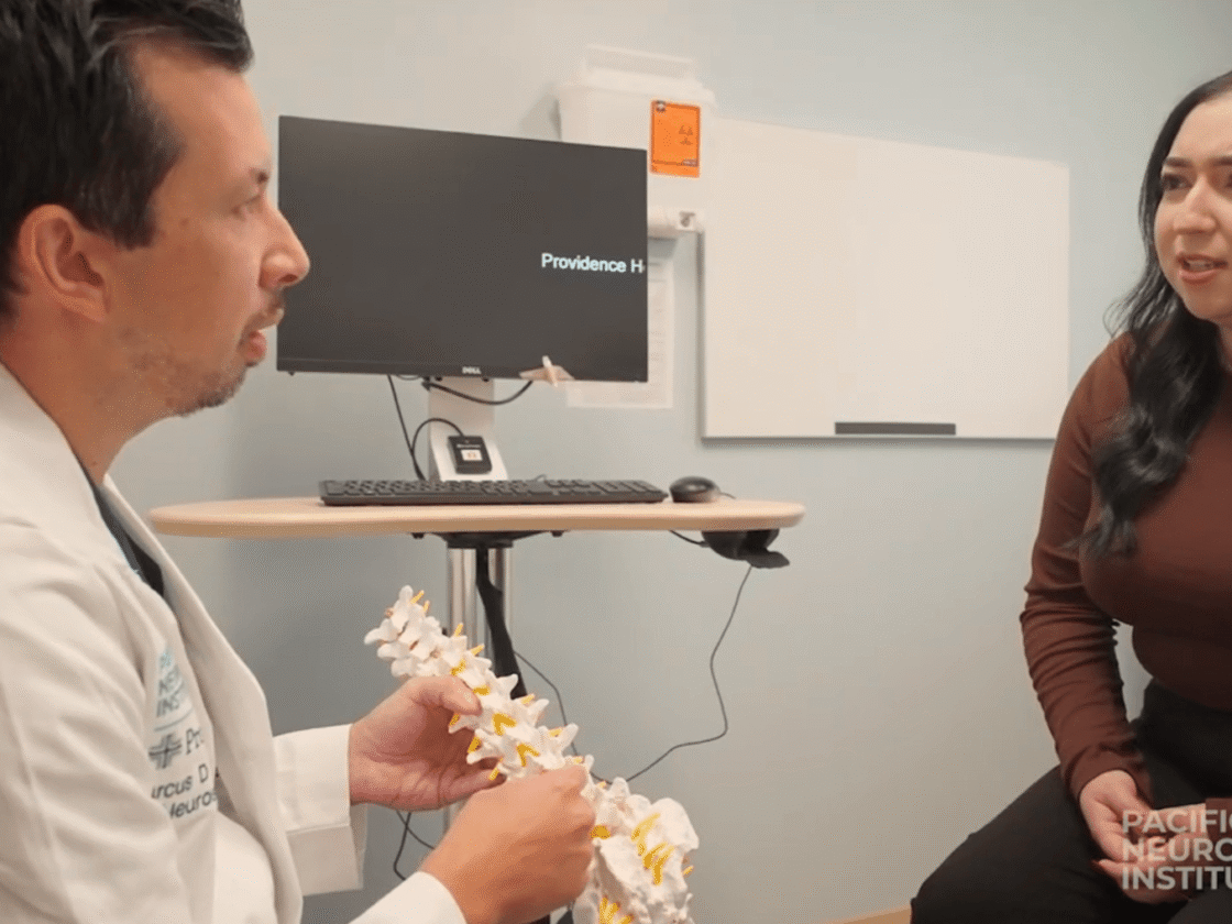 Marcus Mazur, MD discussing spine surgery with a patient