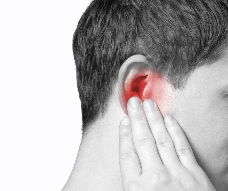 Black and white profile of person touching their ear. Ear is red to symbolize pain.