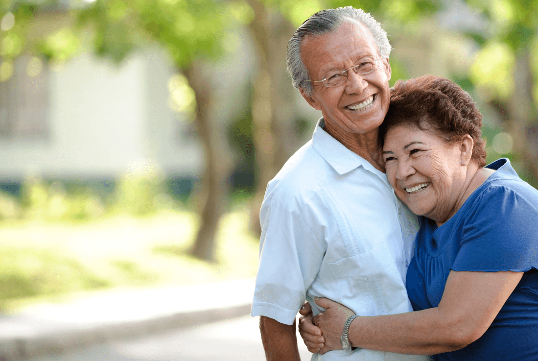 Elderly couple hugging.