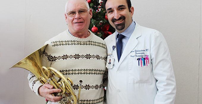 Dr. Garni with a patient who is holding a musical instrument