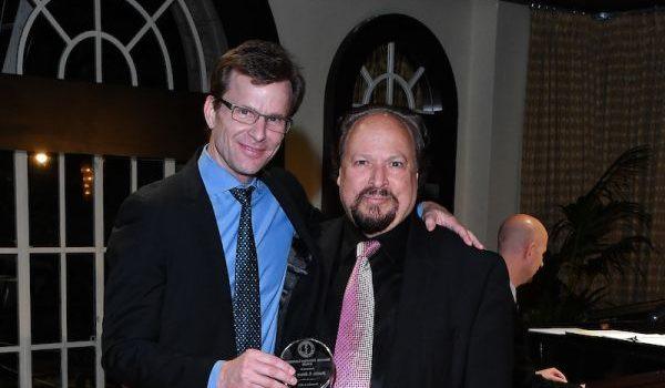 Daniel F Kelly holding an award