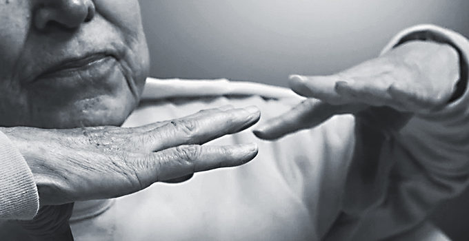 elderly person holding up their hands