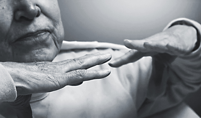 elderly person holding up their hands