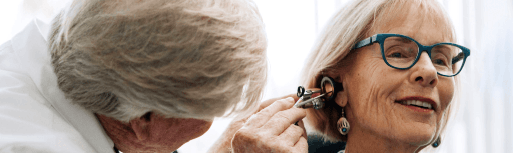 elderly woman receiving an ear exam