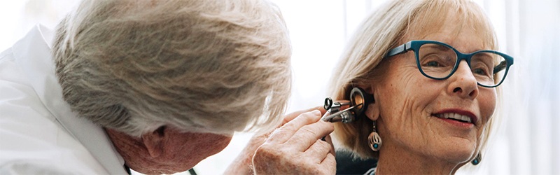 female patient having her ear examined by a doctor