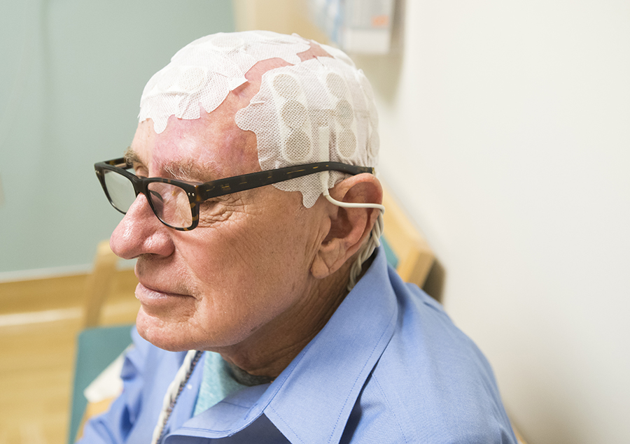 elderly patient with medical sensors on his head