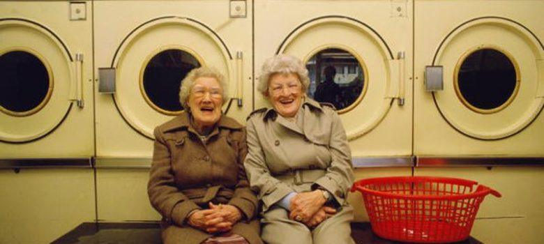 two elderly women sitting in a laundromat