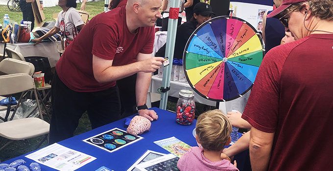 group of people around a booth at a charity event