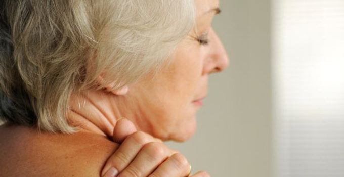 elderly woman holding her shoulder
