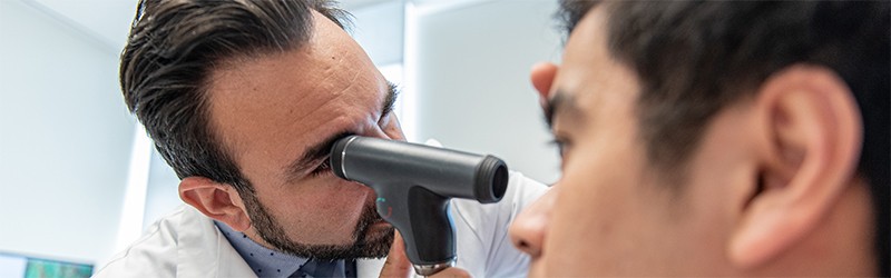 doctor performing an eye exam on his patient