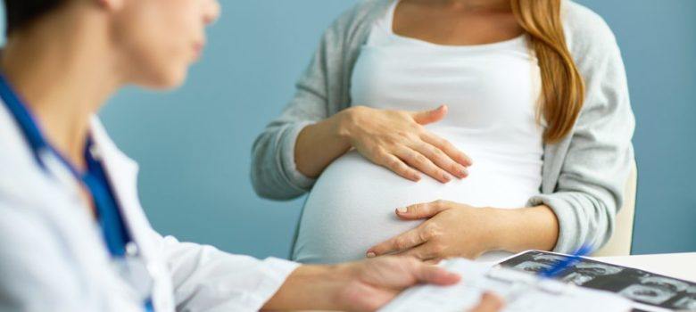 pregnant woman speaking with her doctor