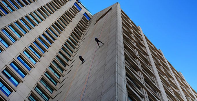 two people scaling the side of a building