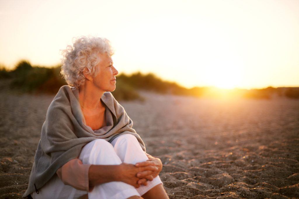 Woman watching the sunset on a beach